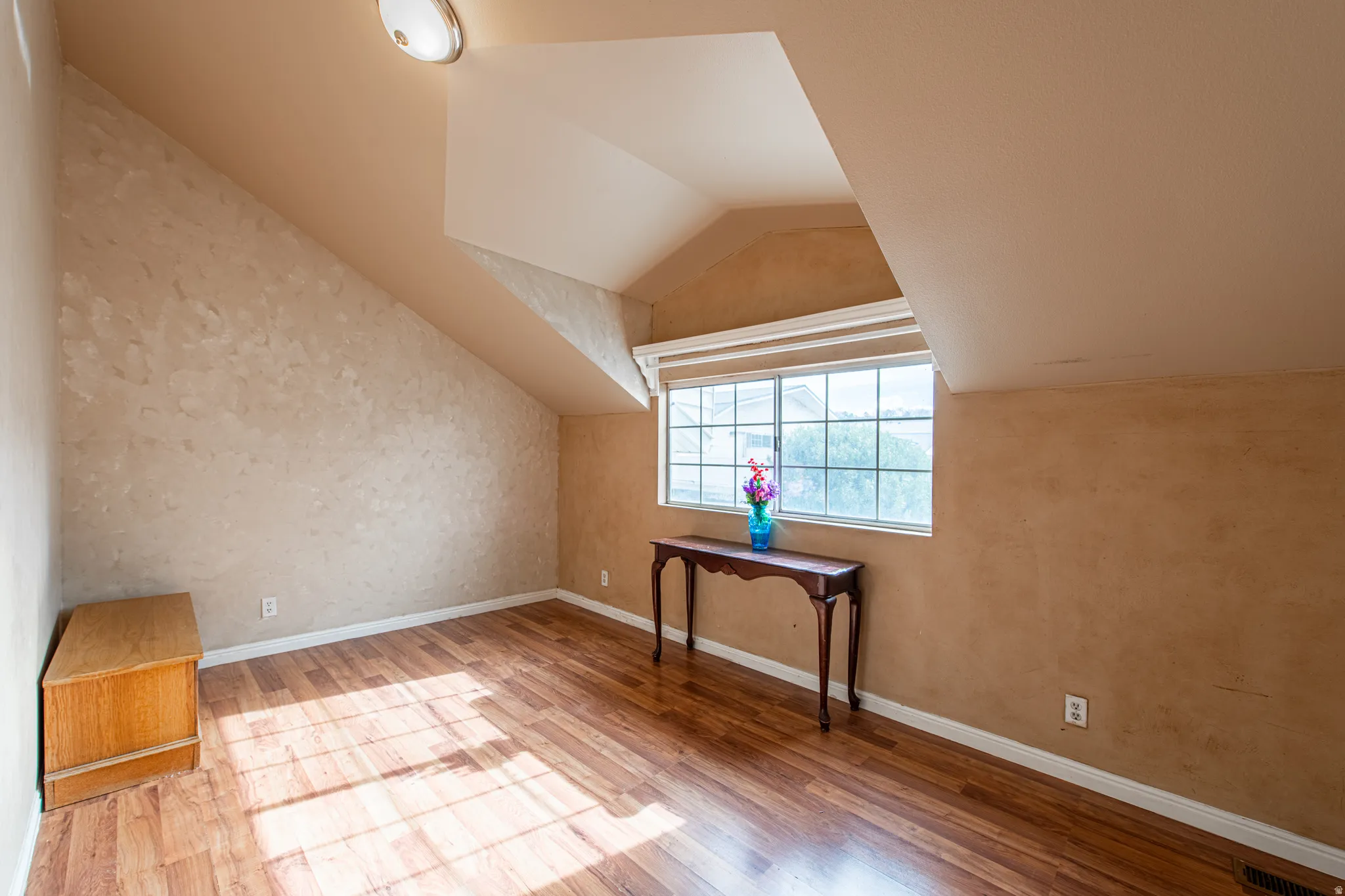 Additional living space featuring vaulted ceiling and wood finished floors