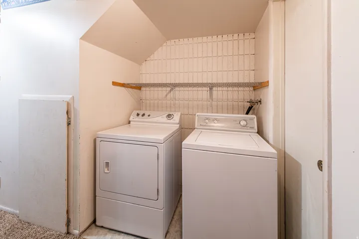 Laundry area with washing machine and dryer and vaulted ceiling