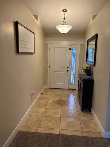 Doorway featuring tile patterned floors and a textured ceiling