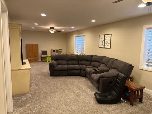 Living room with ceiling fan, recessed lighting, and light colored carpet