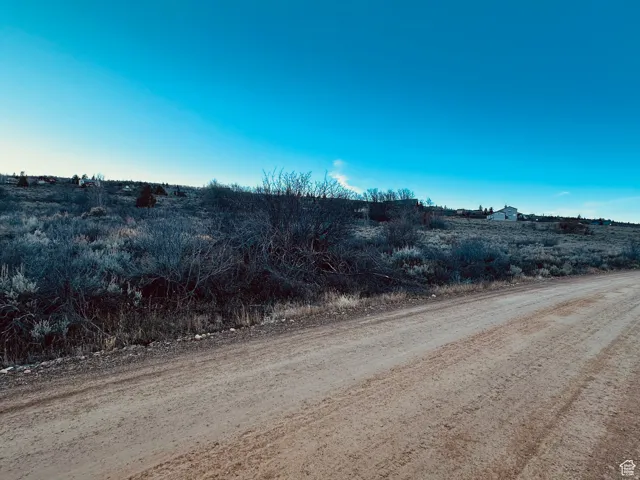 View of dirt / gravel road featuring a view of rural / pastoral area