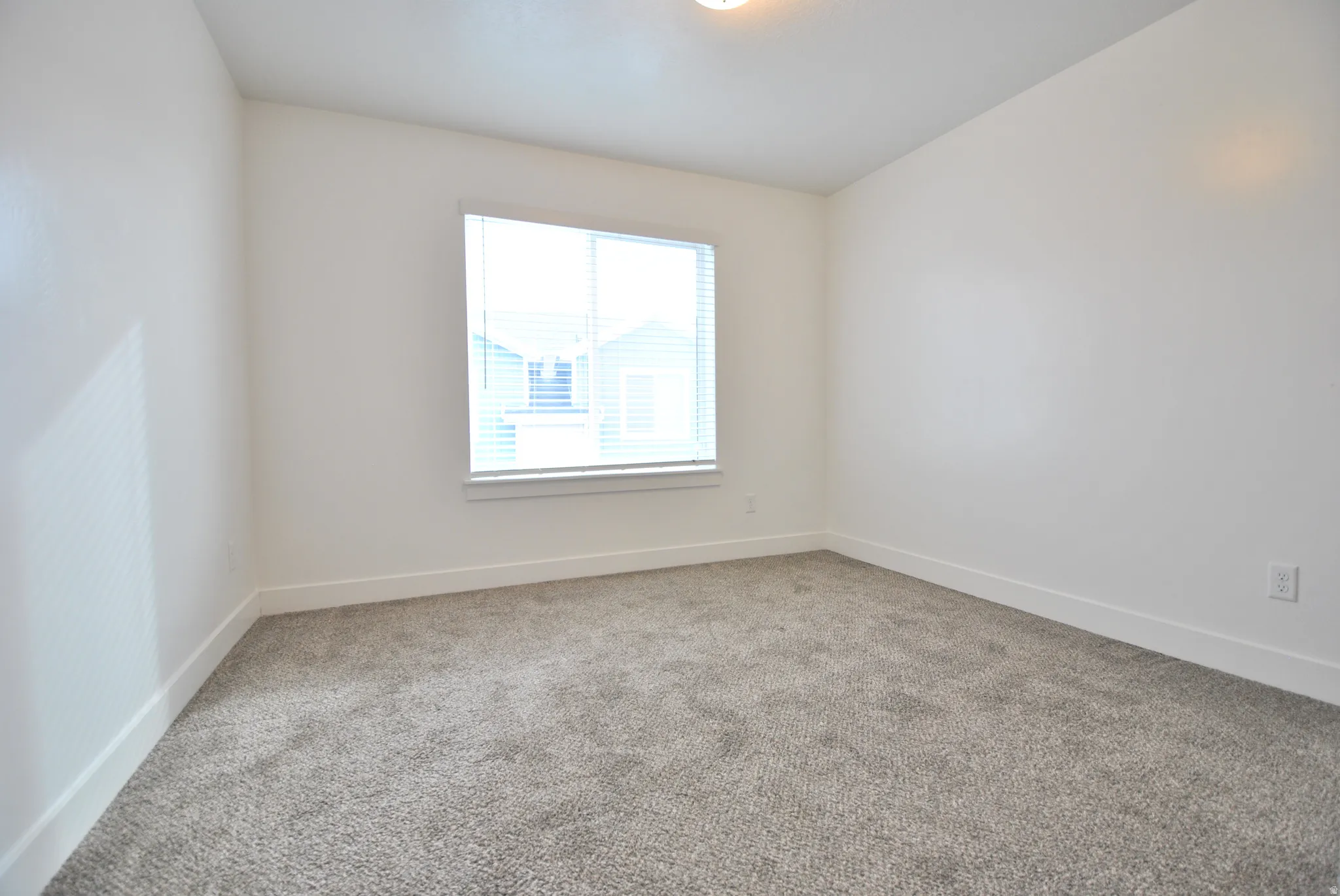 Bedroom with light carpet and baseboards