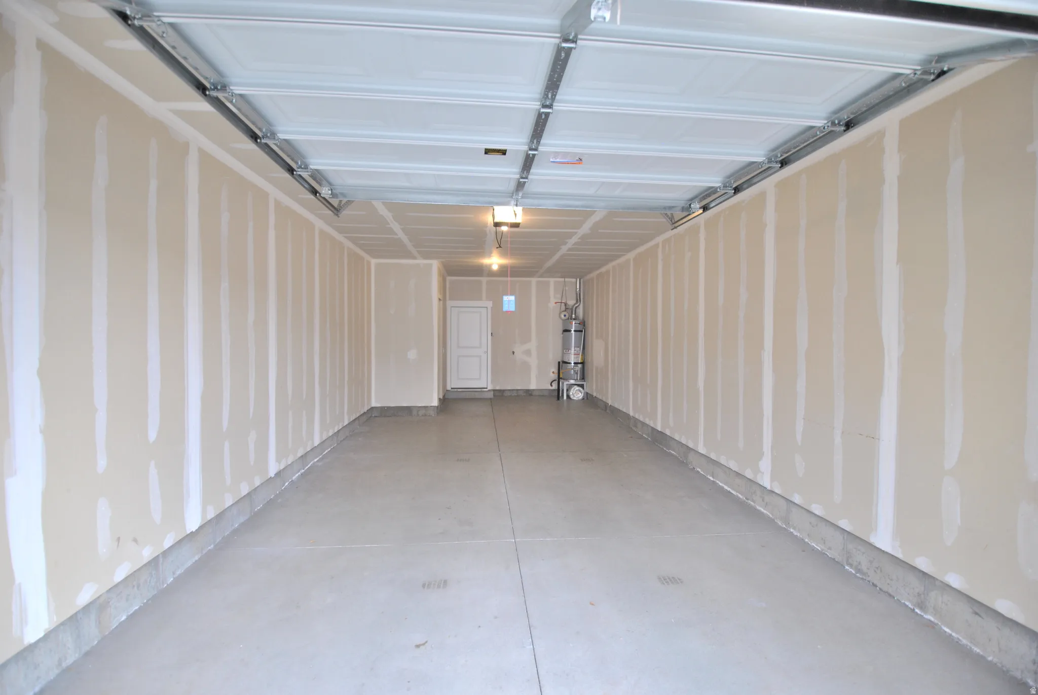 Garage featuring strapped water heater