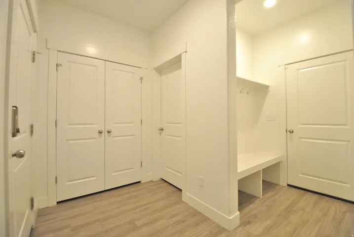 Mudroom featuring light wood-style flooring and recessed lighting