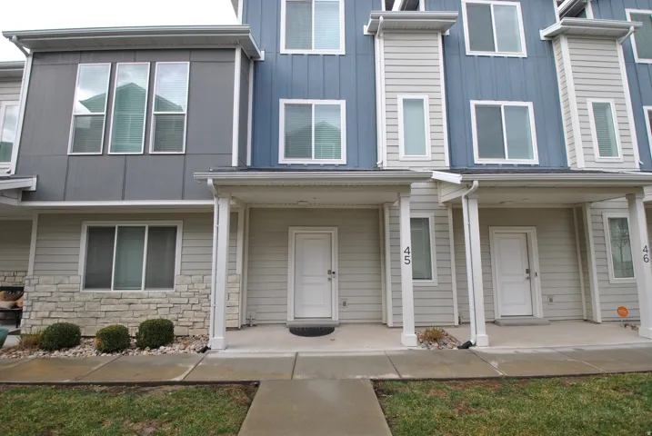 Doorway to property featuring a porch, stone siding, and board and batten siding