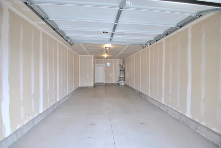 Garage featuring strapped water heater