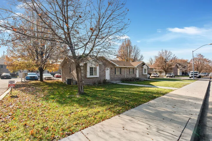 View of front of home featuring a residential view, brick siding, and a front yard