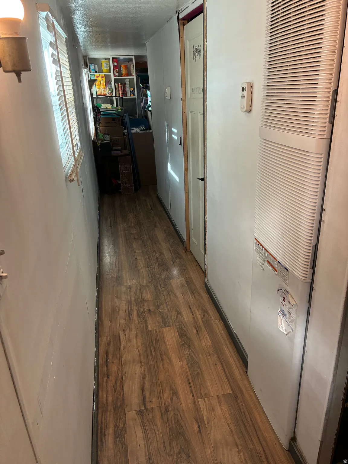 Hallway featuring dark wood-style floors and a heating unit