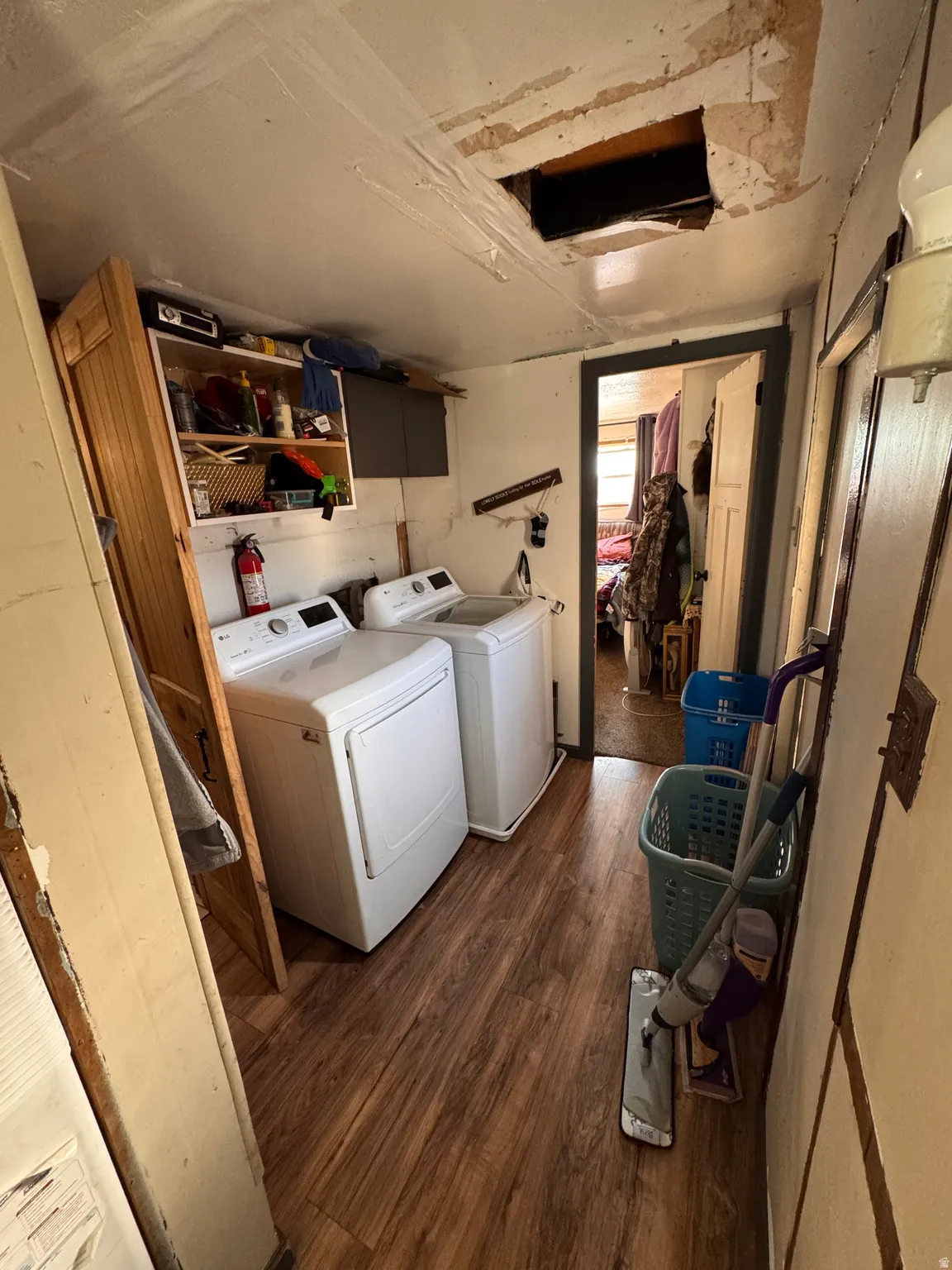 Laundry area with dark wood-type flooring and independent washer and dryer