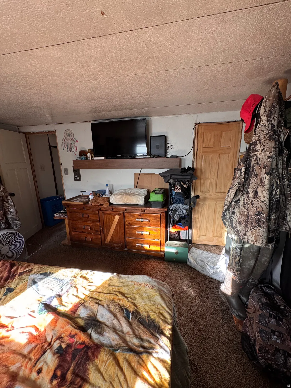 Bedroom featuring dark colored carpet and a textured ceiling