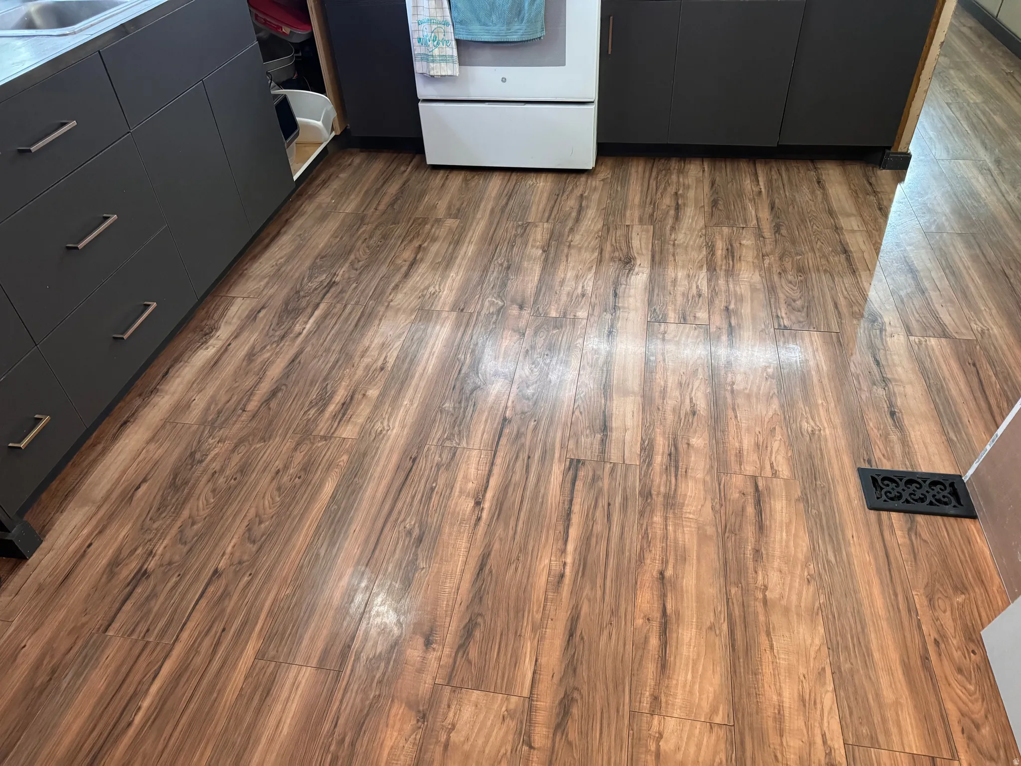 Kitchen view of dark wood finished floors, white range oven, modern cabinets, and dual tone cabinetry