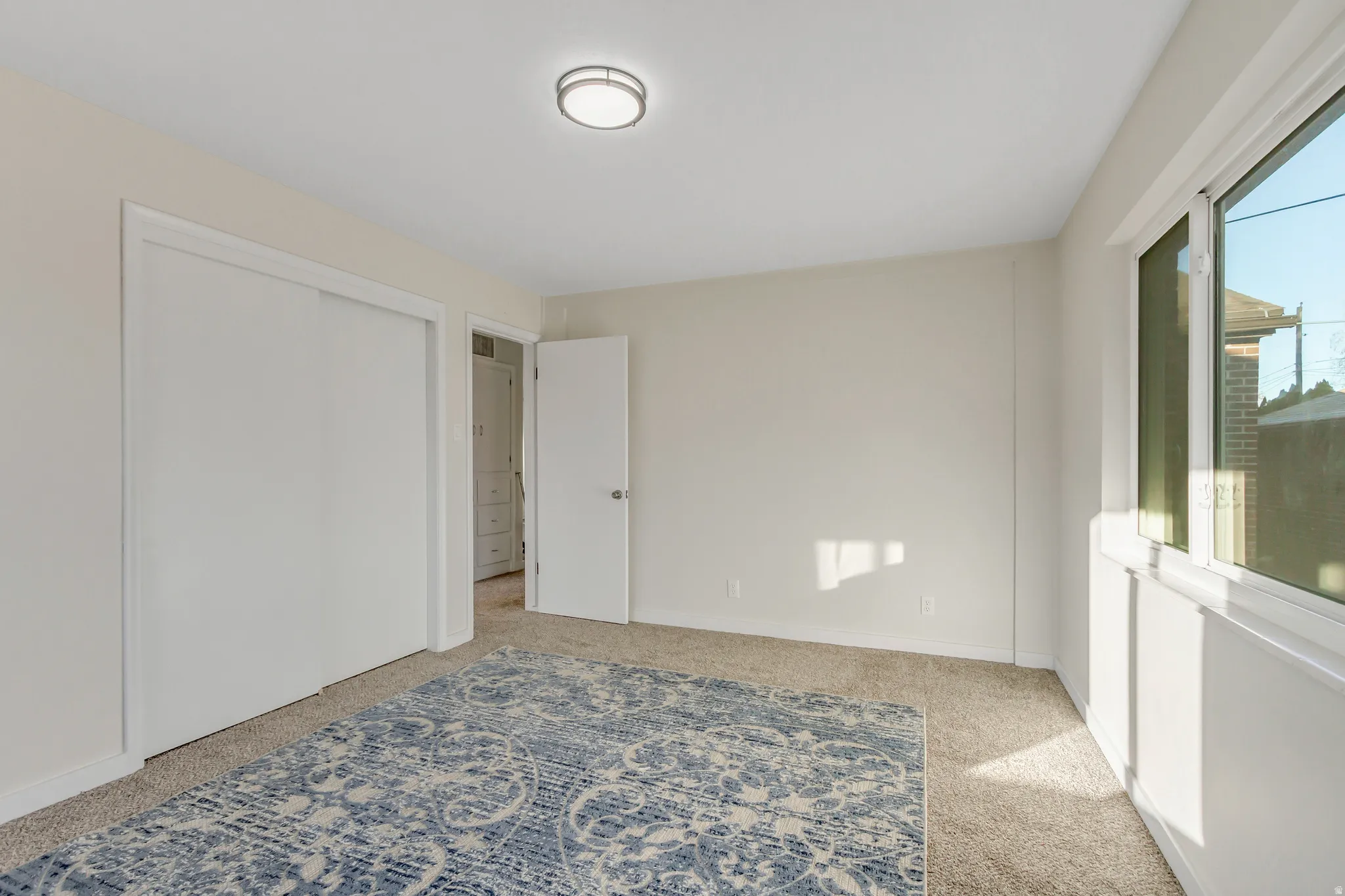 Unfurnished bedroom with light colored carpet and a closet