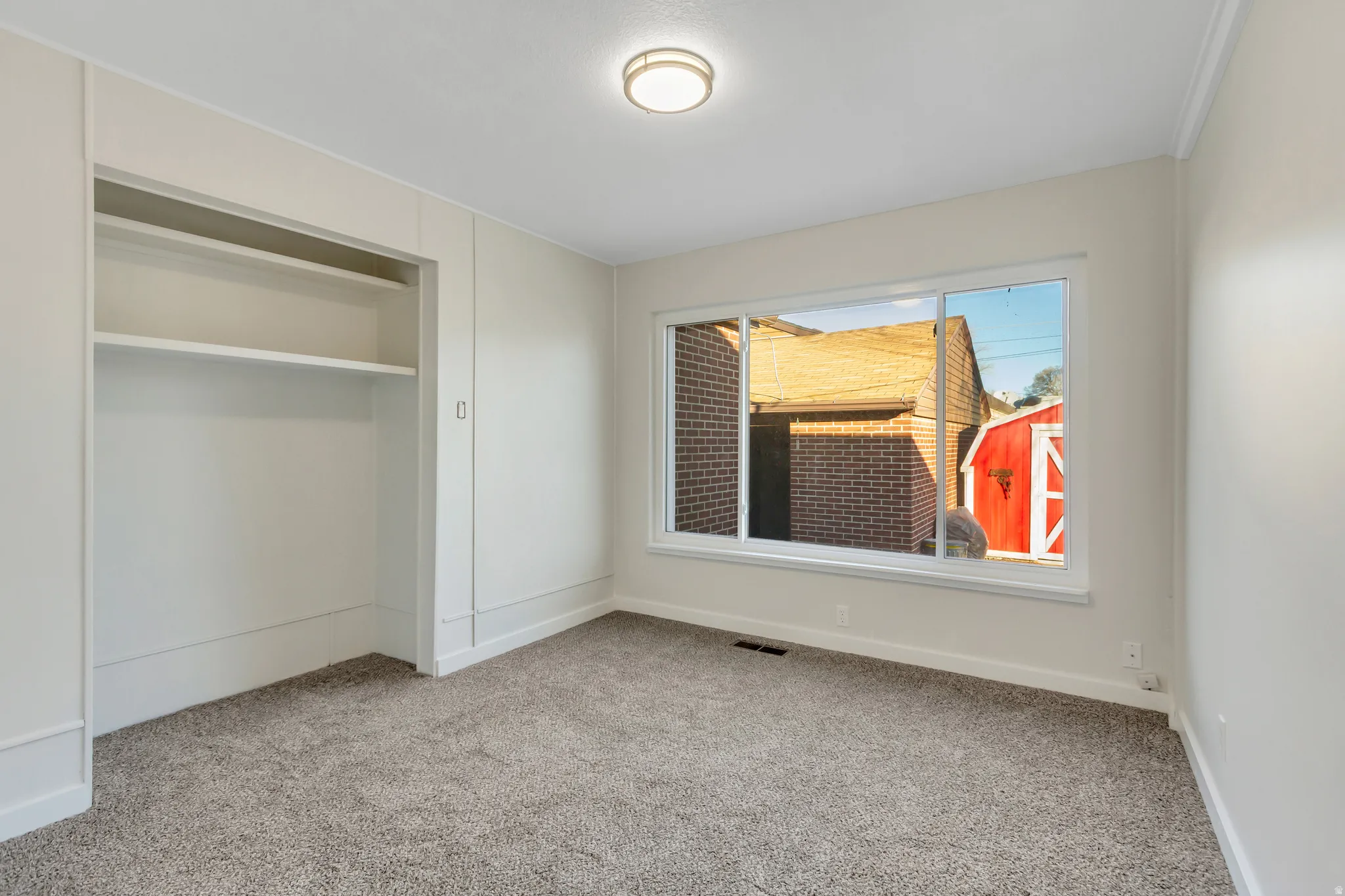 Unfurnished bedroom with light carpet and a closet