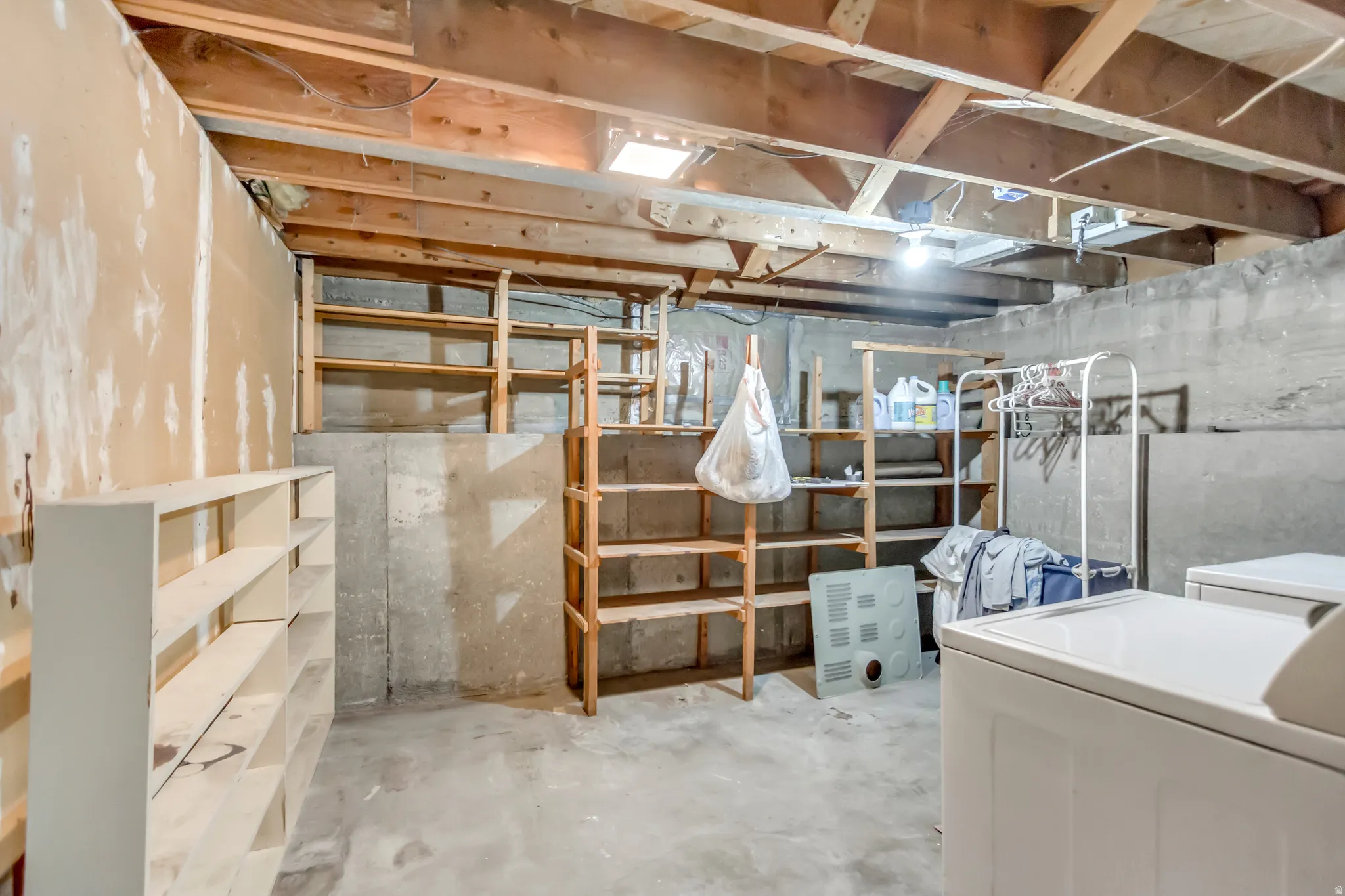 Unfinished below grade area with washing machine and dryer