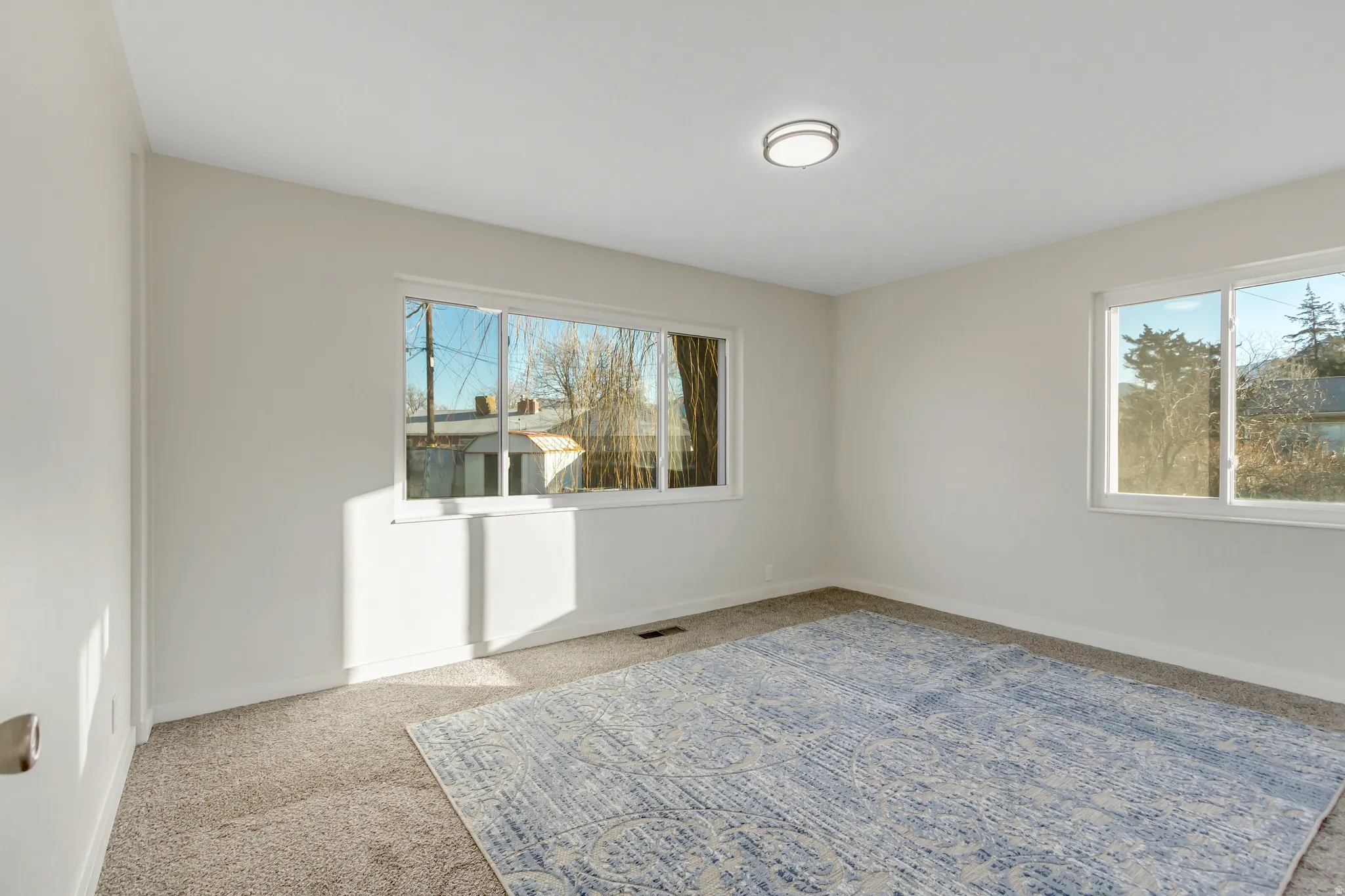 Empty room with light carpet and baseboards