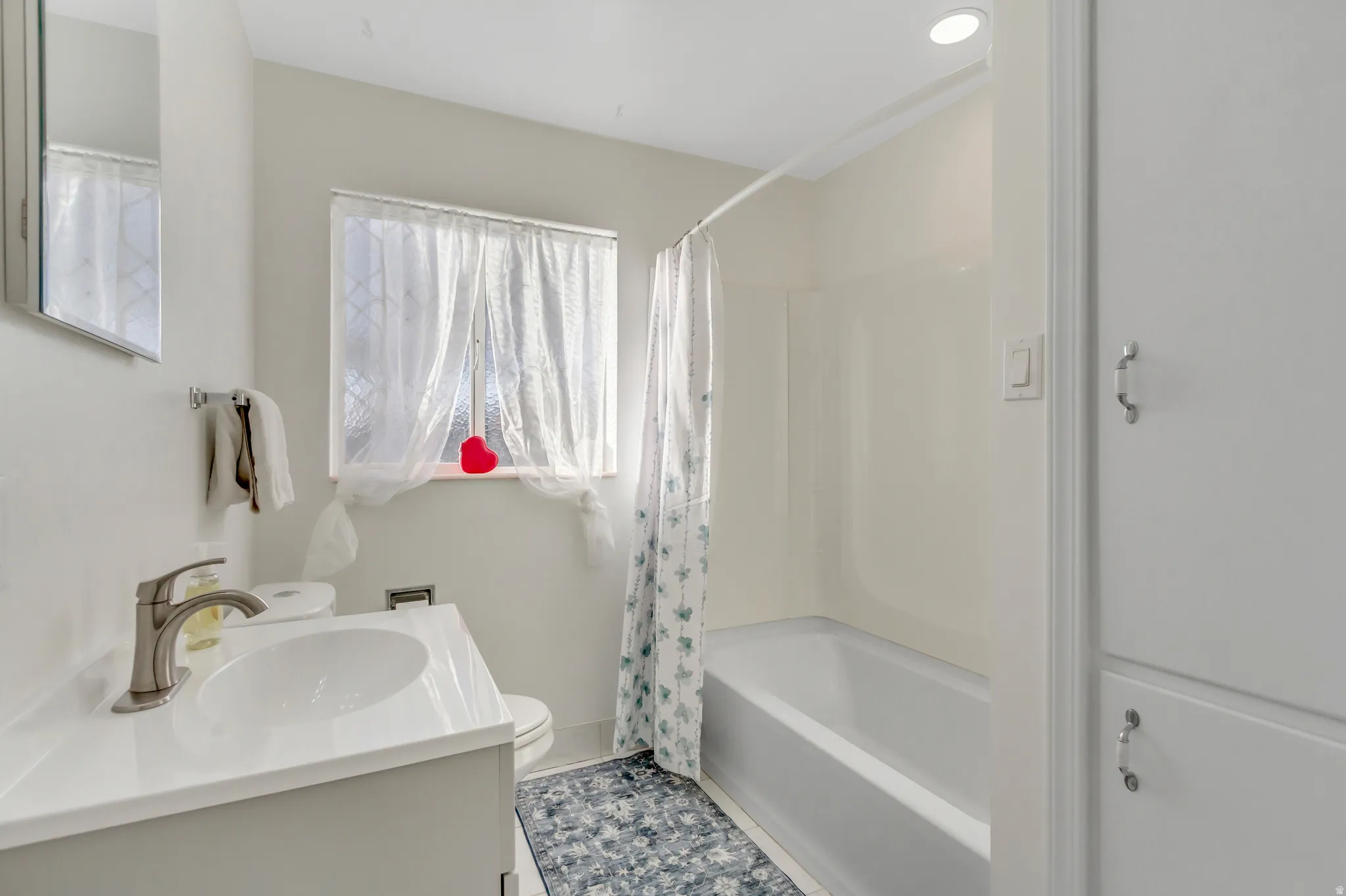 Full bath with shower / bath combo with shower curtain and vanity