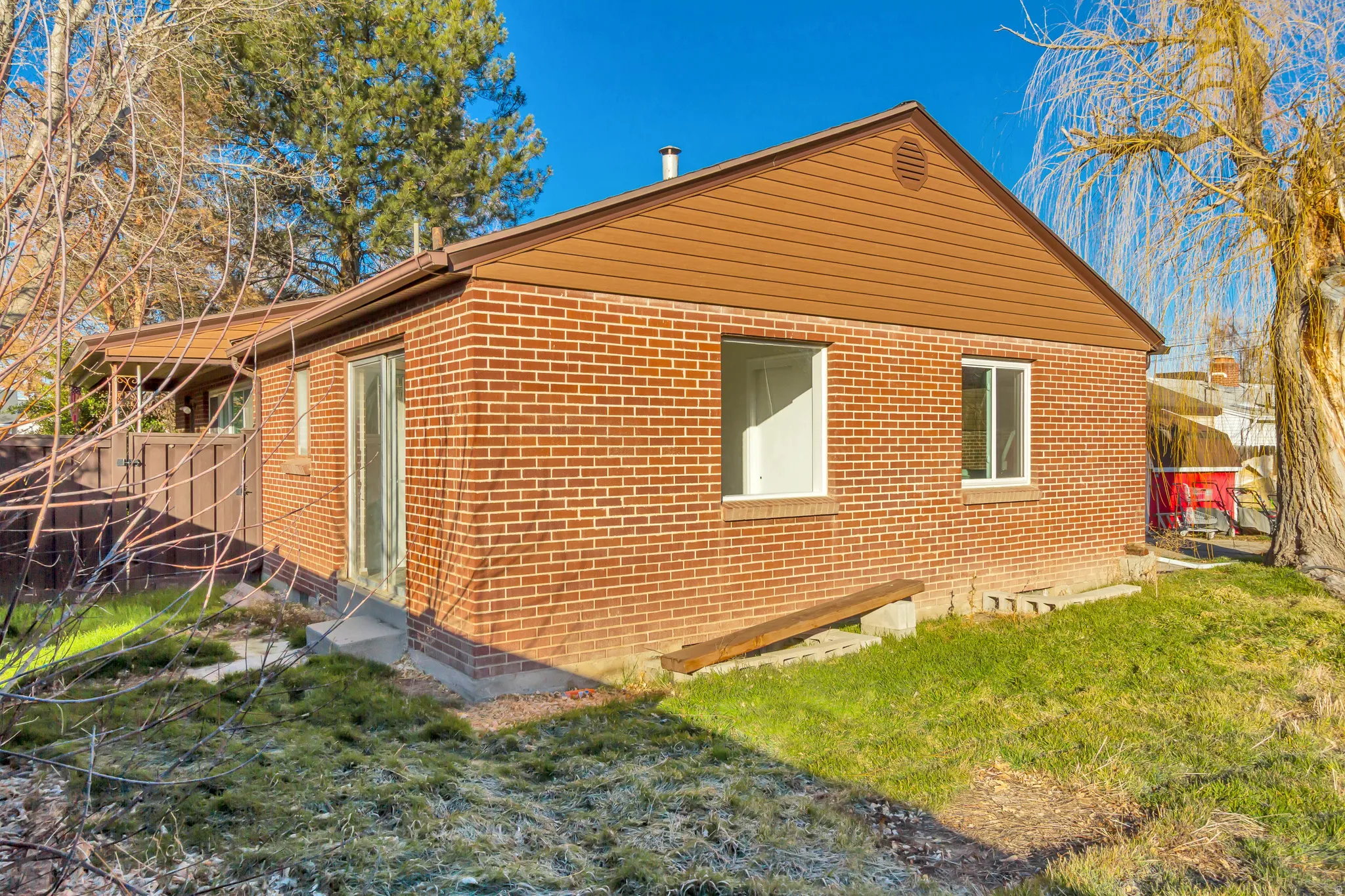 View of property exterior featuring a yard and brick siding