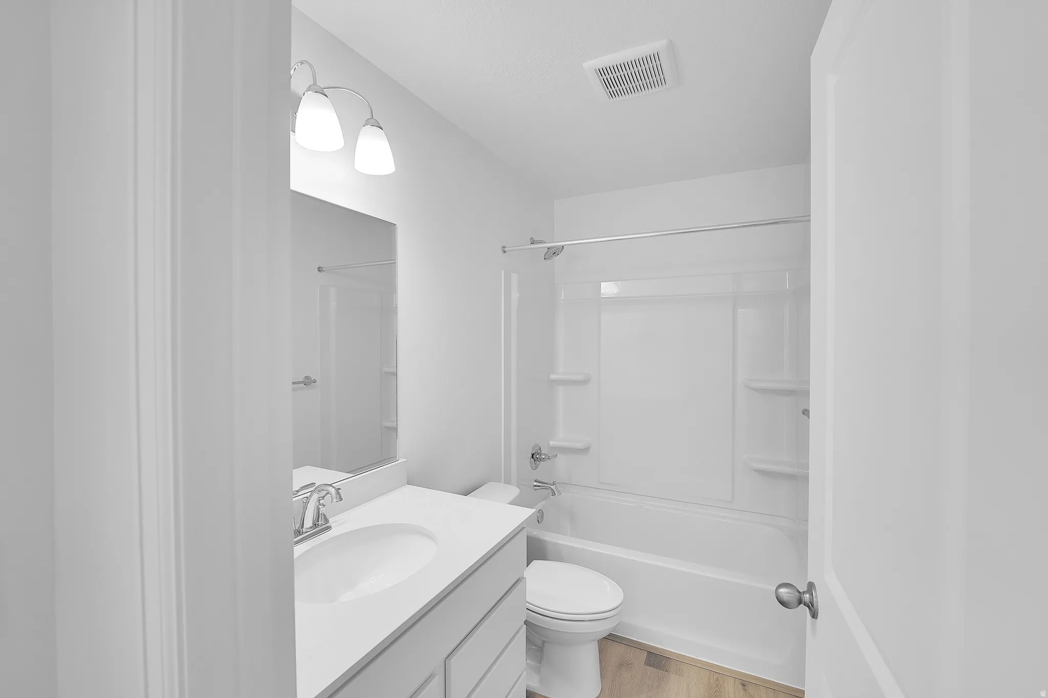 Full bath with vanity, tub / shower combination, and light wood-style floors