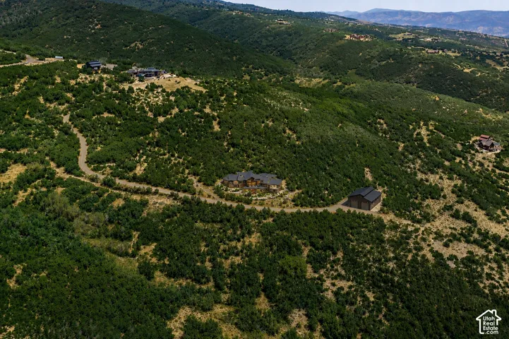 Expansive hillside property featuring a main residence, a secondary building, and a winding driveway