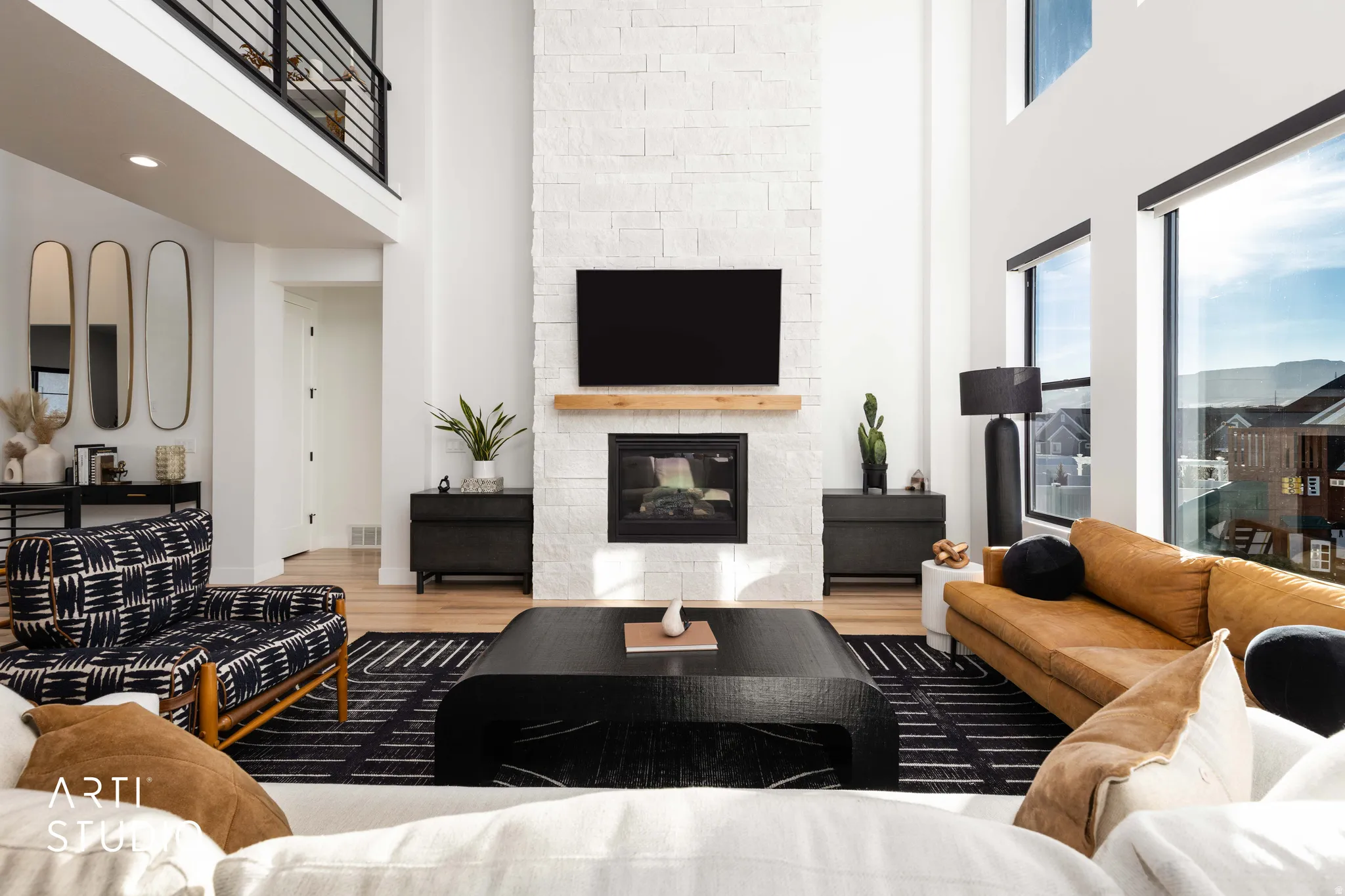 Living area featuring a towering ceiling, wood finished floors, and a fireplace