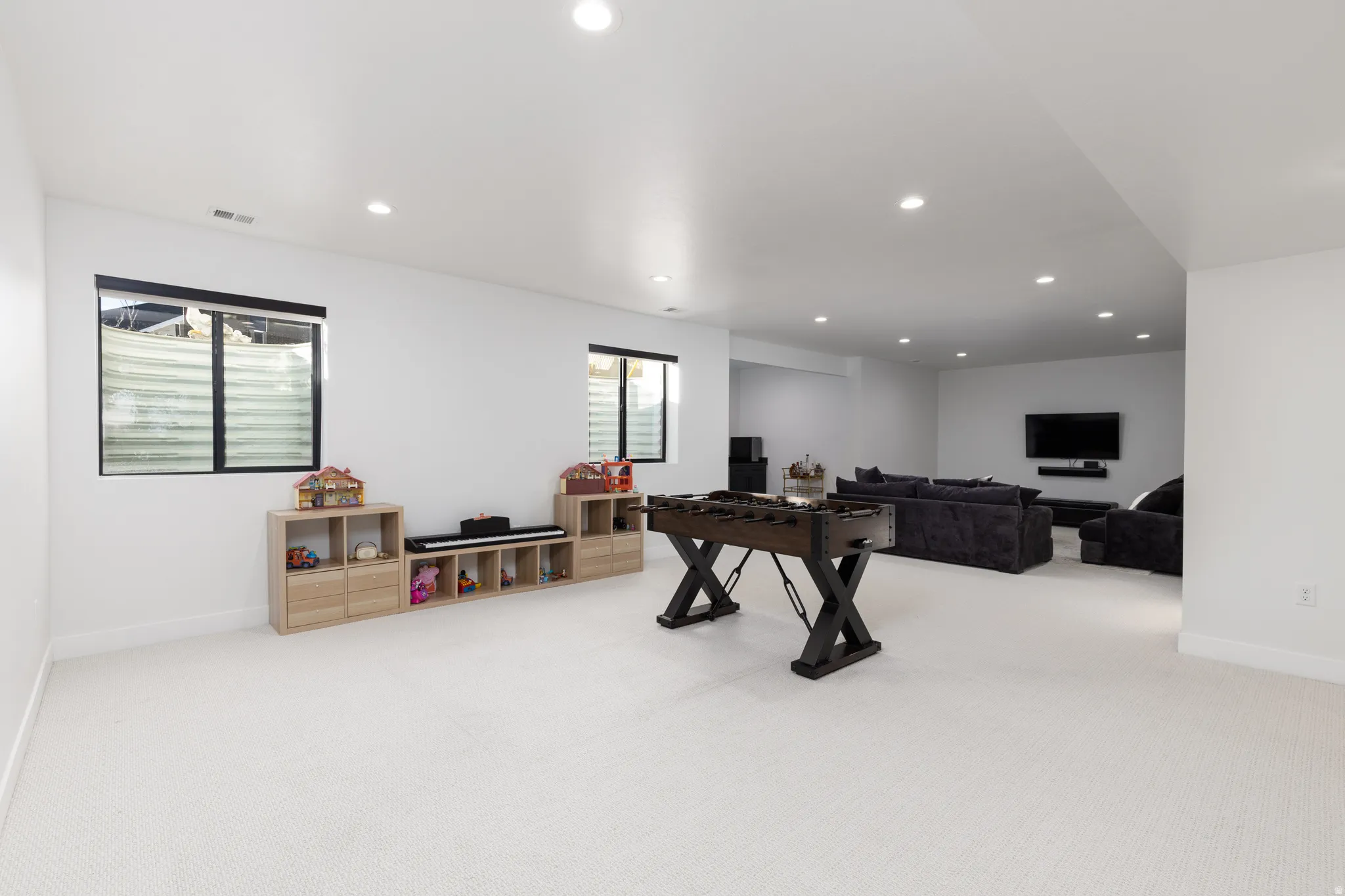 Rec room with light colored carpet and recessed lighting