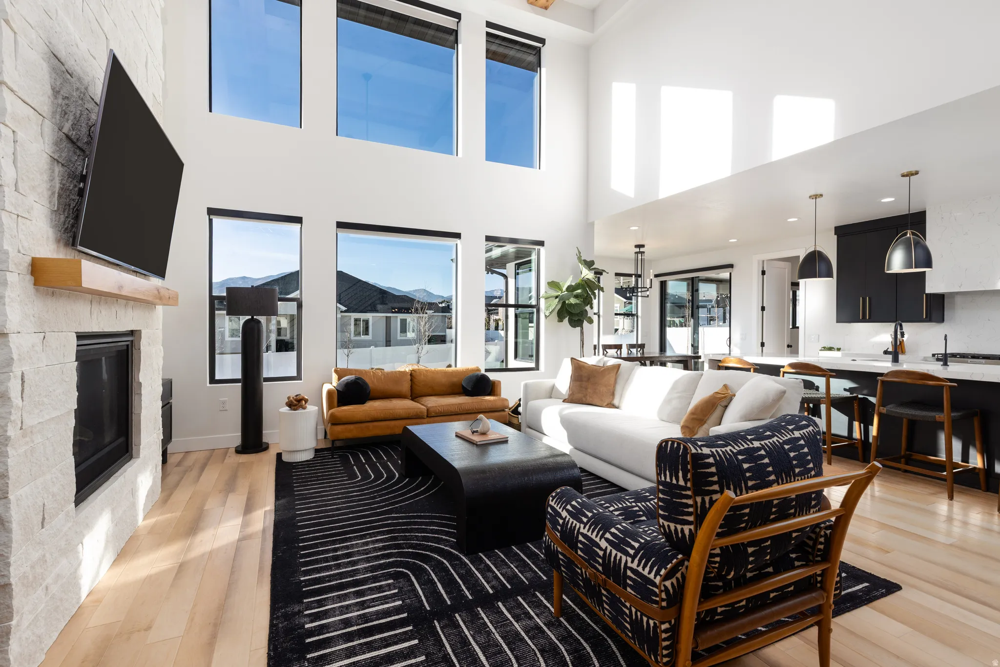 Living room featuring light wood-type flooring, a fireplace, and a high ceiling