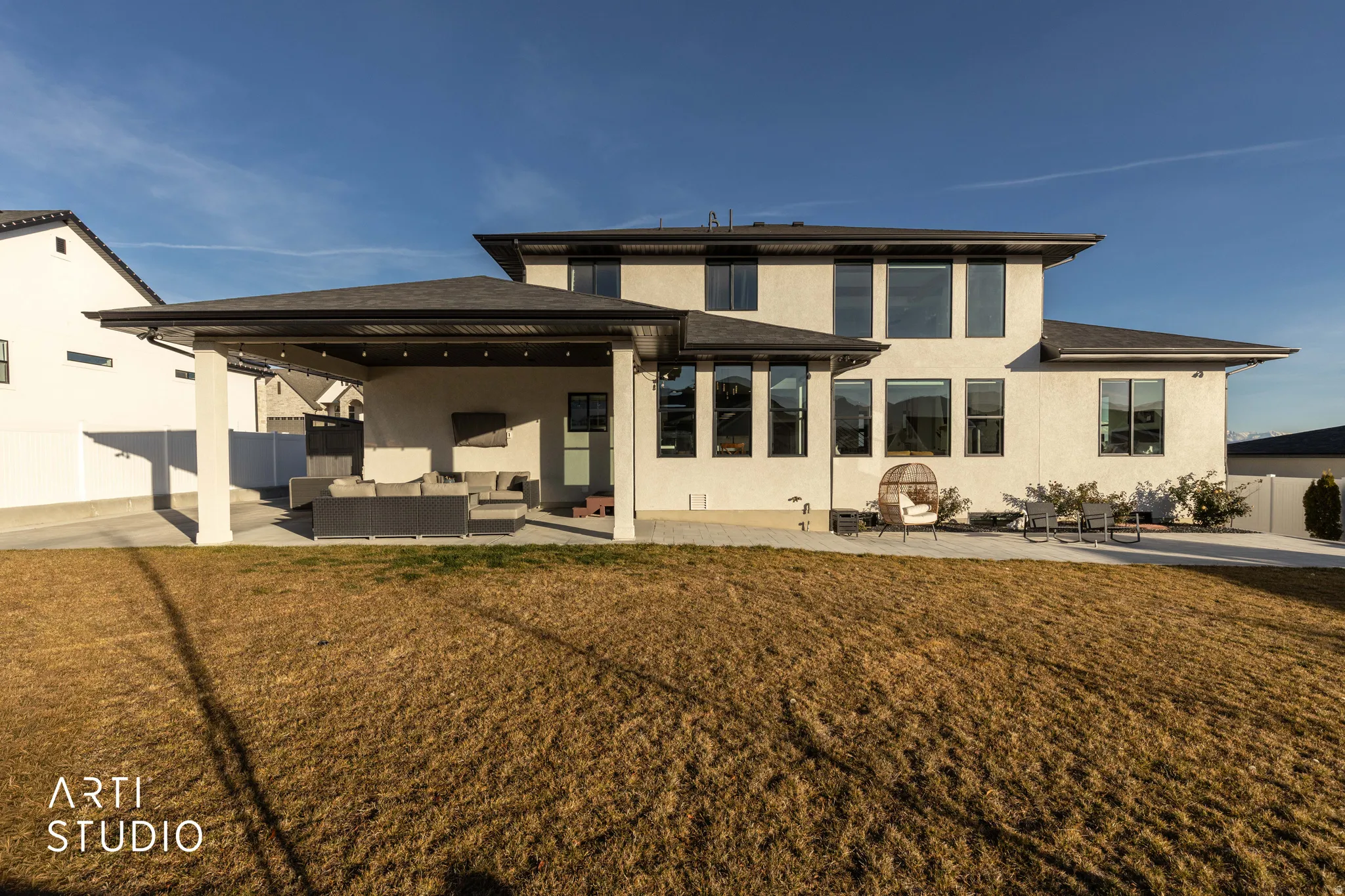 Rear view of house featuring a fenced backyard, stucco siding, a patio area, and an outdoor hangout area