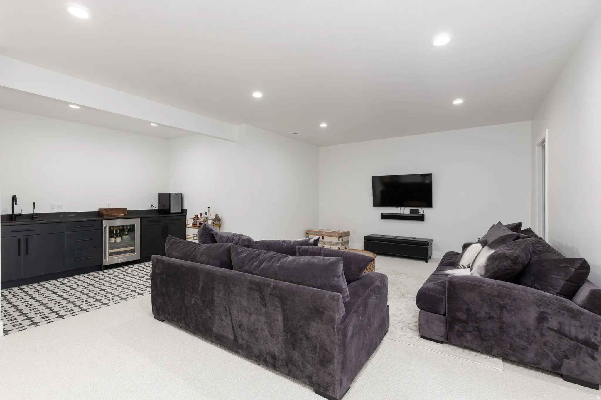 Living room featuring bar with sink, beverage cooler, light carpet, and recessed lighting