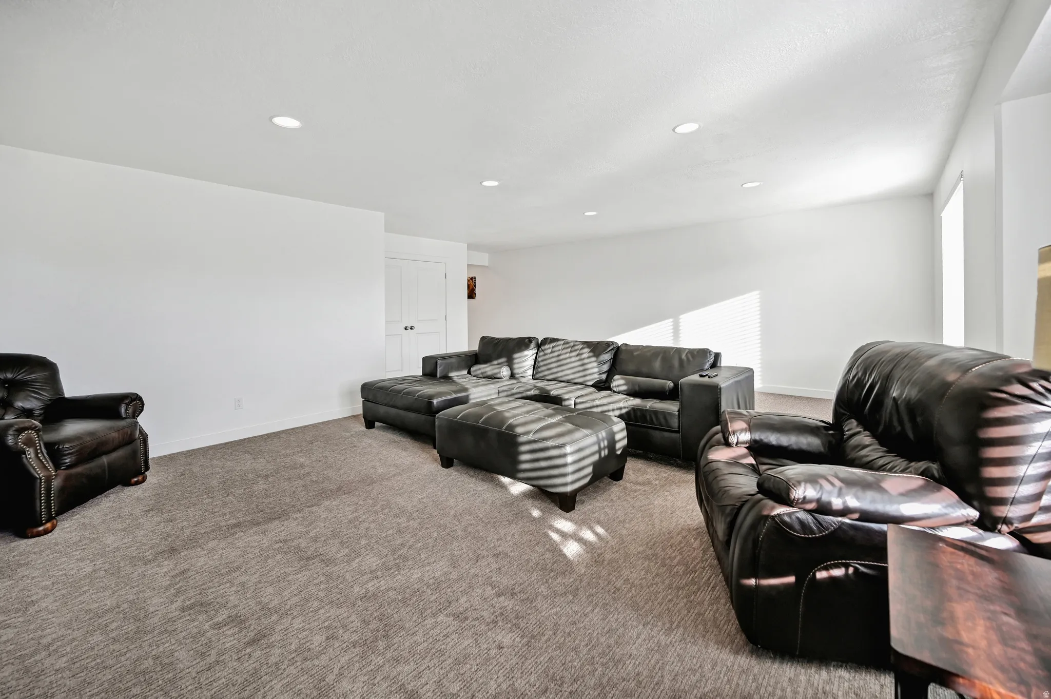 Carpeted living area featuring baseboards and recessed lighting