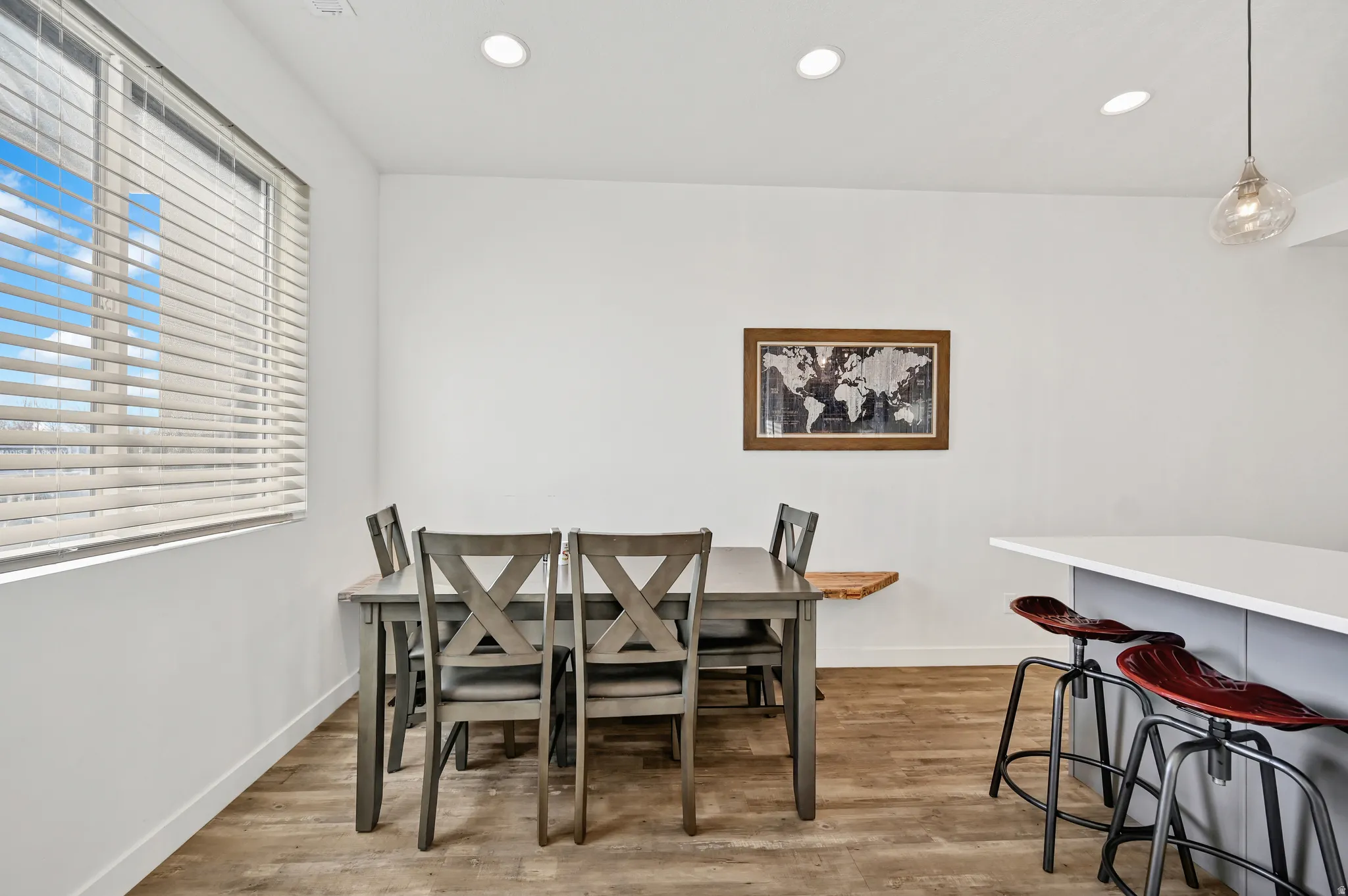 Dining room with light wood-style floors and recessed lighting