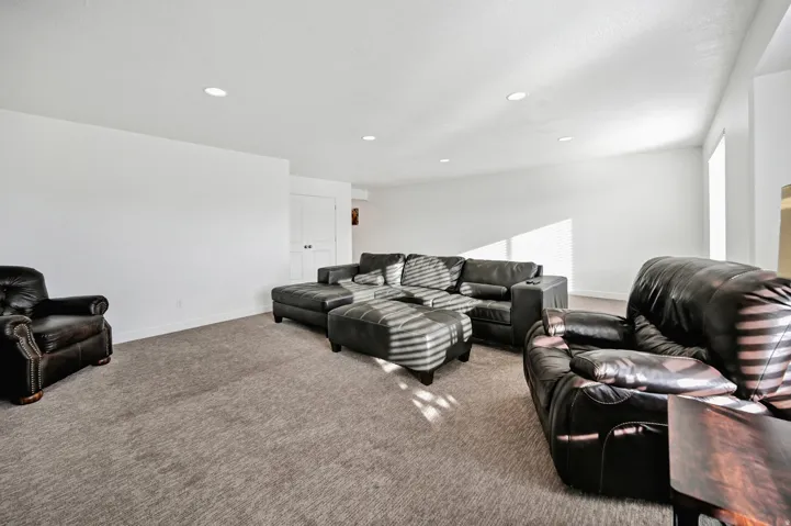 Carpeted living area featuring baseboards and recessed lighting