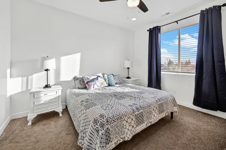 Bedroom featuring dark carpet and a ceiling fan