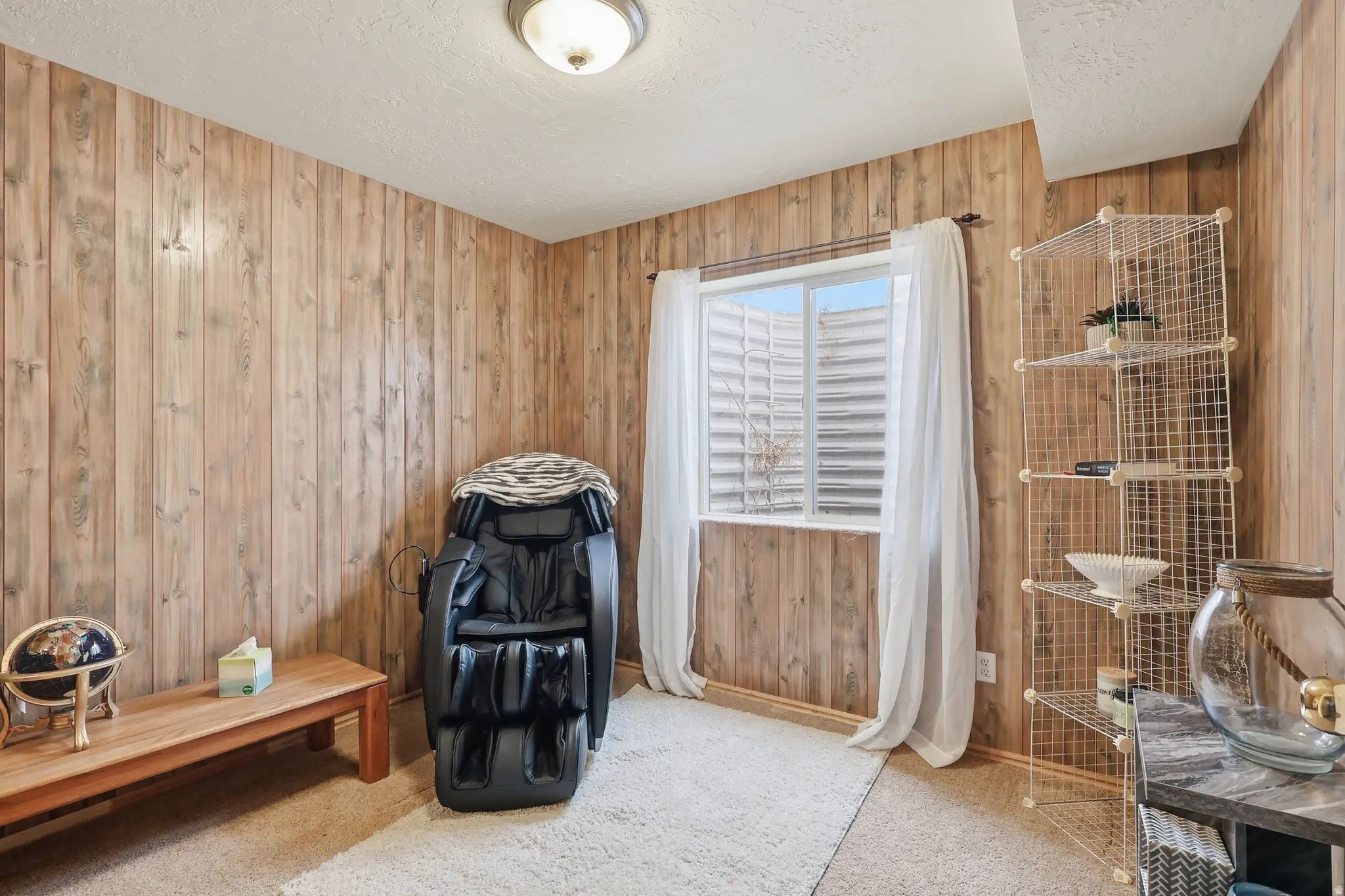Misc room with carpet, a textured ceiling, and wood walls