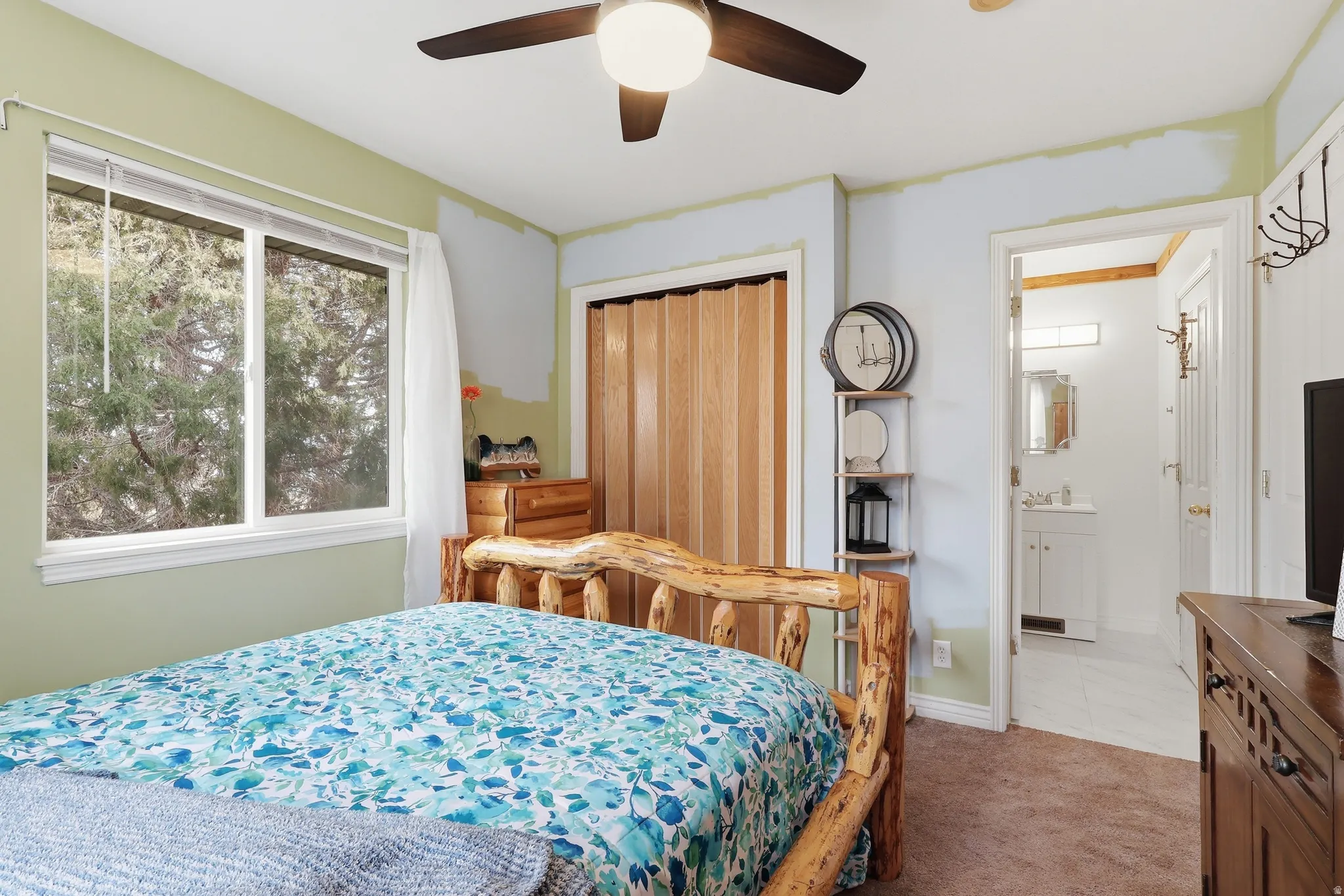 Bedroom featuring carpet flooring, ceiling fan, a closet, and ensuite bathroom