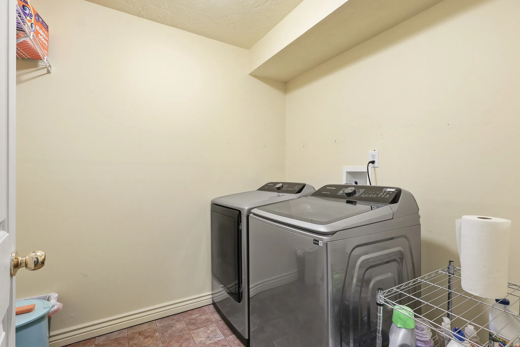 Laundry room with washer and clothes dryer and a textured ceiling