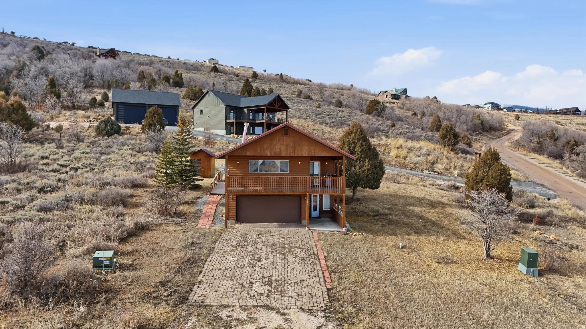 View of front of home with driveway, a garage, and a view of countryside
