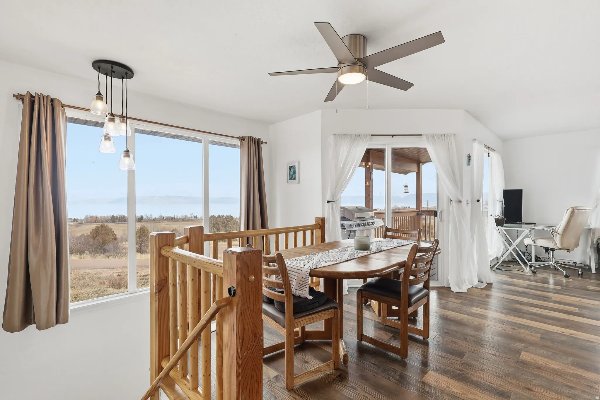 Dining space featuring dark wood-style flooring, a desk, and a ceiling fan