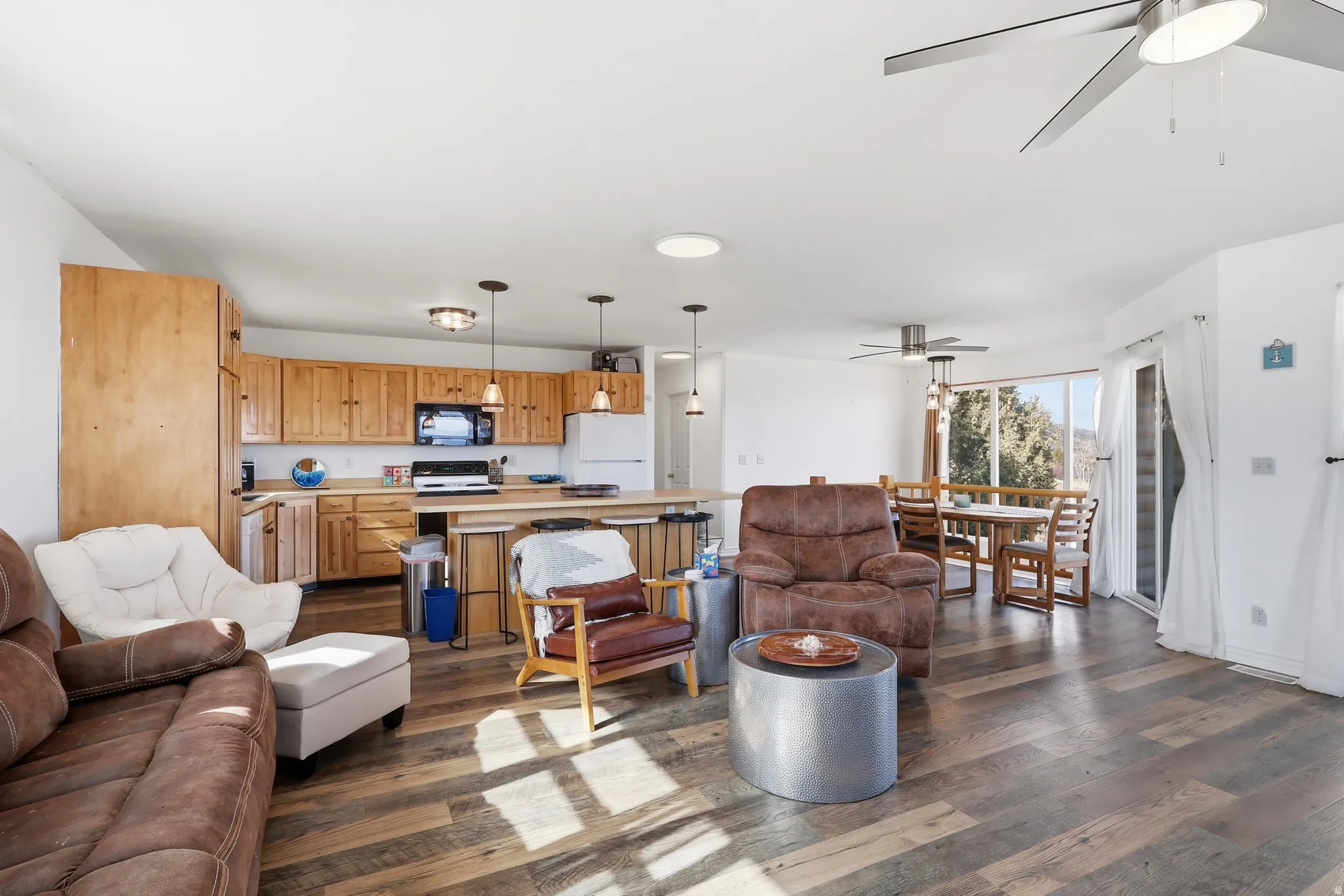 Living room with a ceiling fan and dark wood finished floors