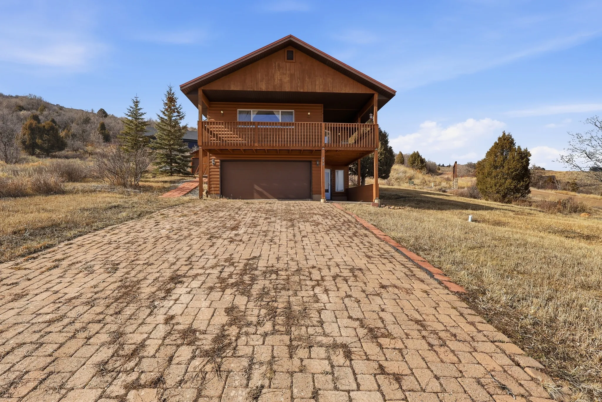 View of front of home featuring a garage and decorative driveway