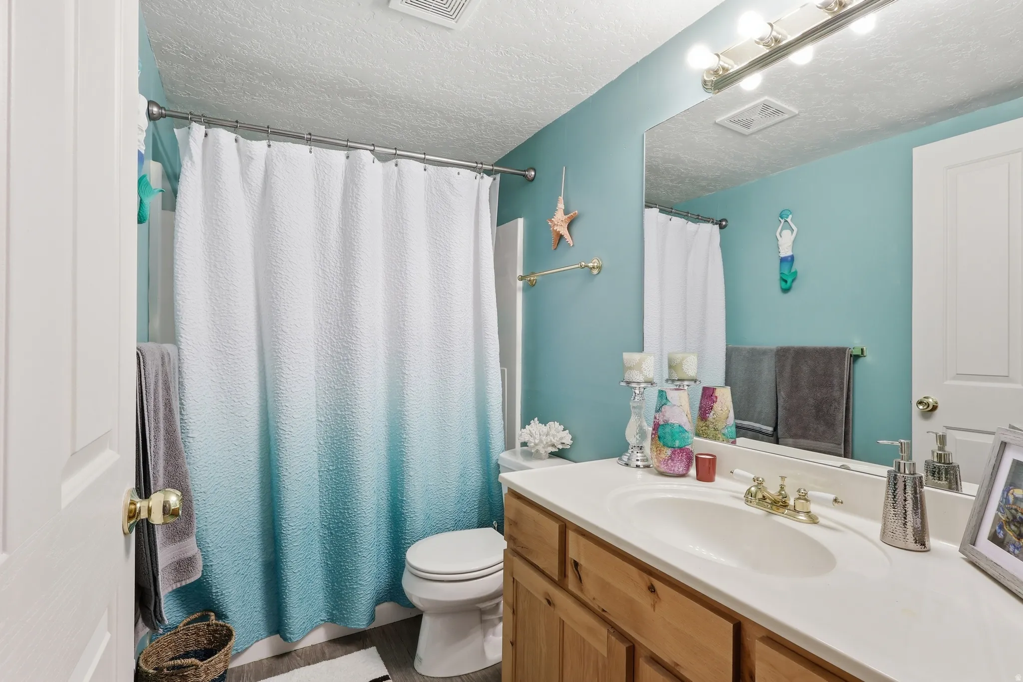 Full bath with vanity, a textured ceiling, and a shower with shower curtain