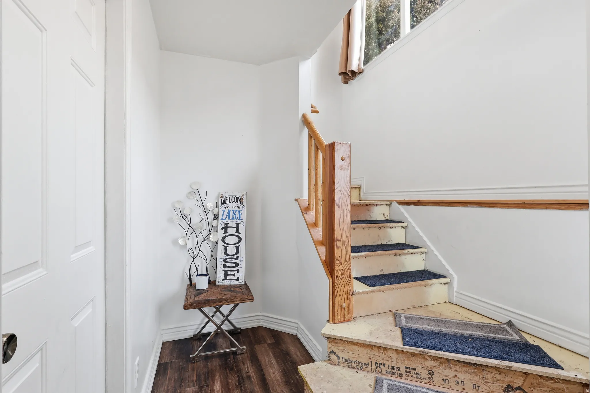 Stairway with wood finished floors and baseboards