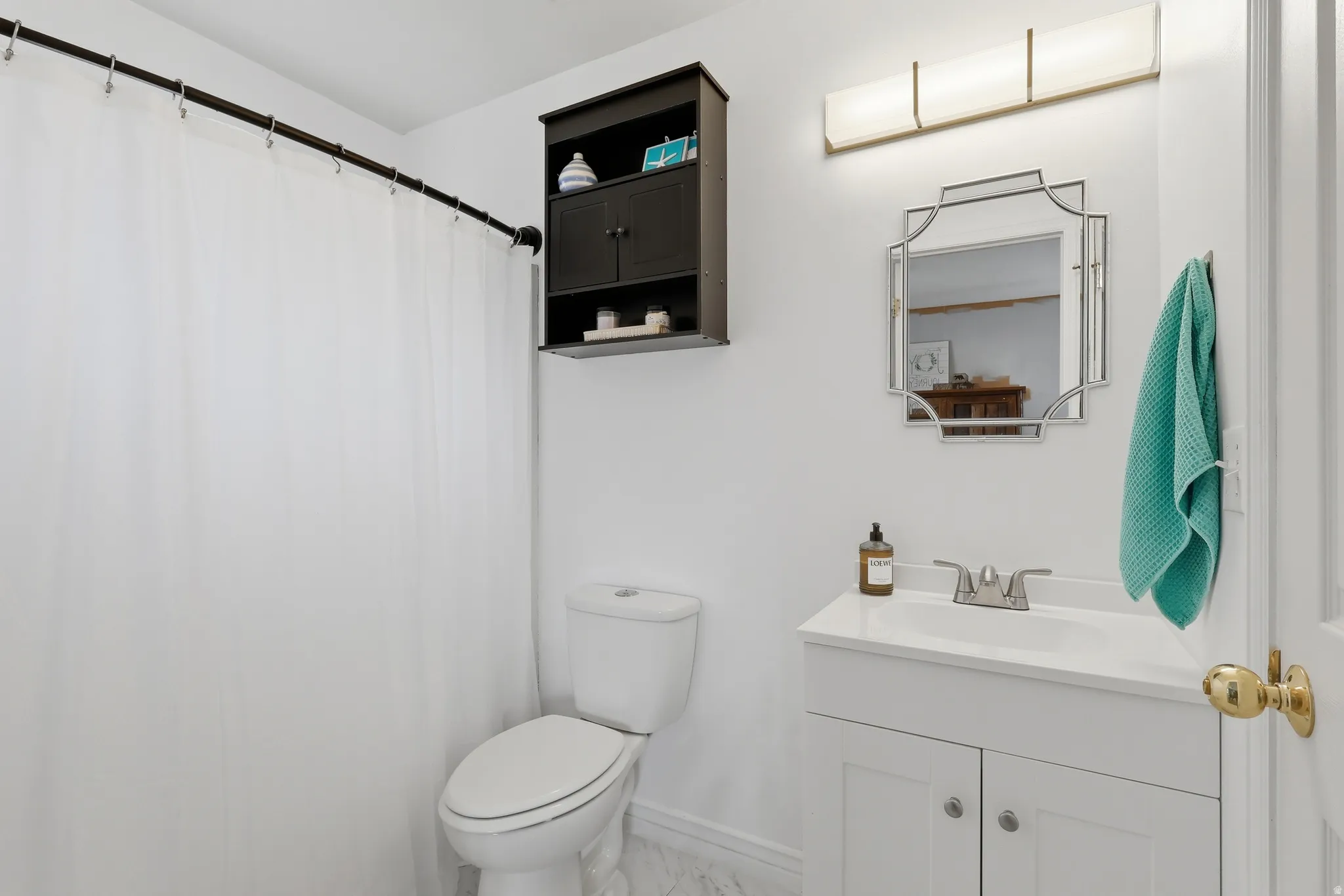 Bathroom with vanity, curtained shower, and light marble finish floors