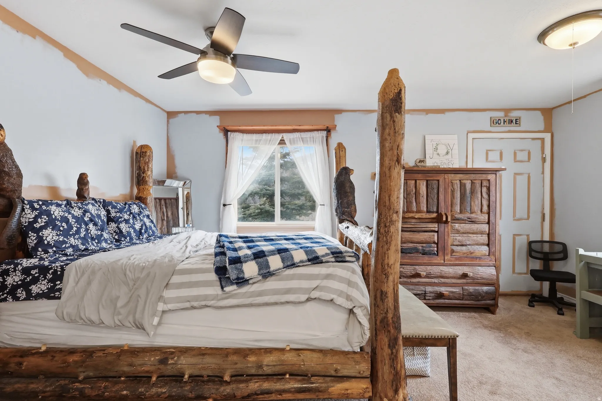 Bedroom with light colored carpet and a ceiling fan