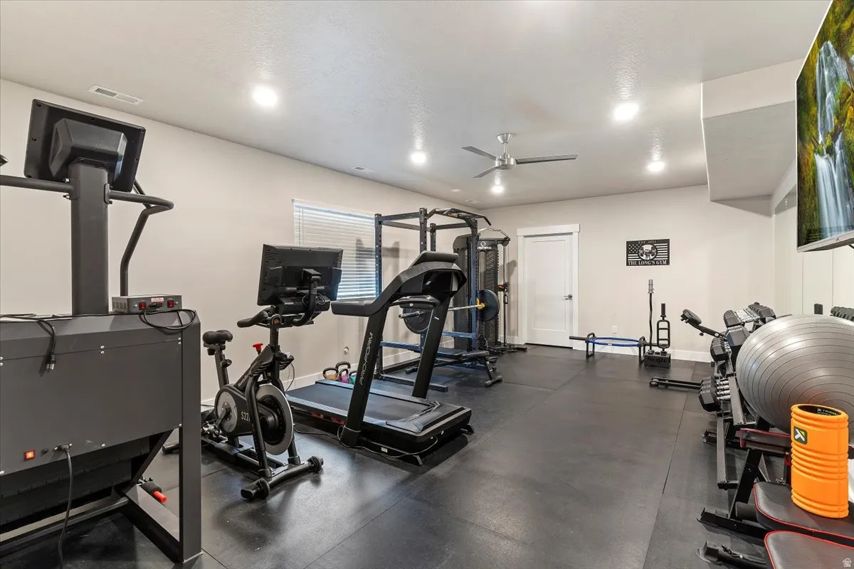 Workout area featuring a ceiling fan and recessed lighting