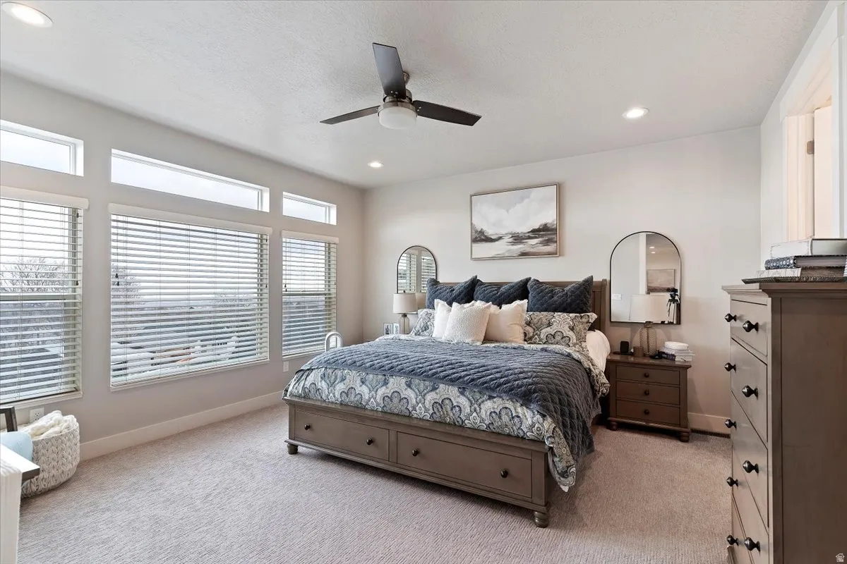 Bedroom with light carpet, a ceiling fan, and recessed lighting