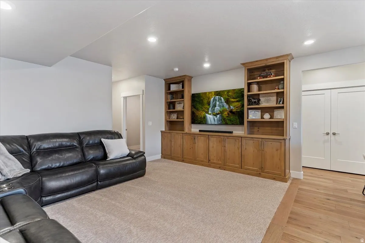 Living area with light wood-type flooring and recessed lighting