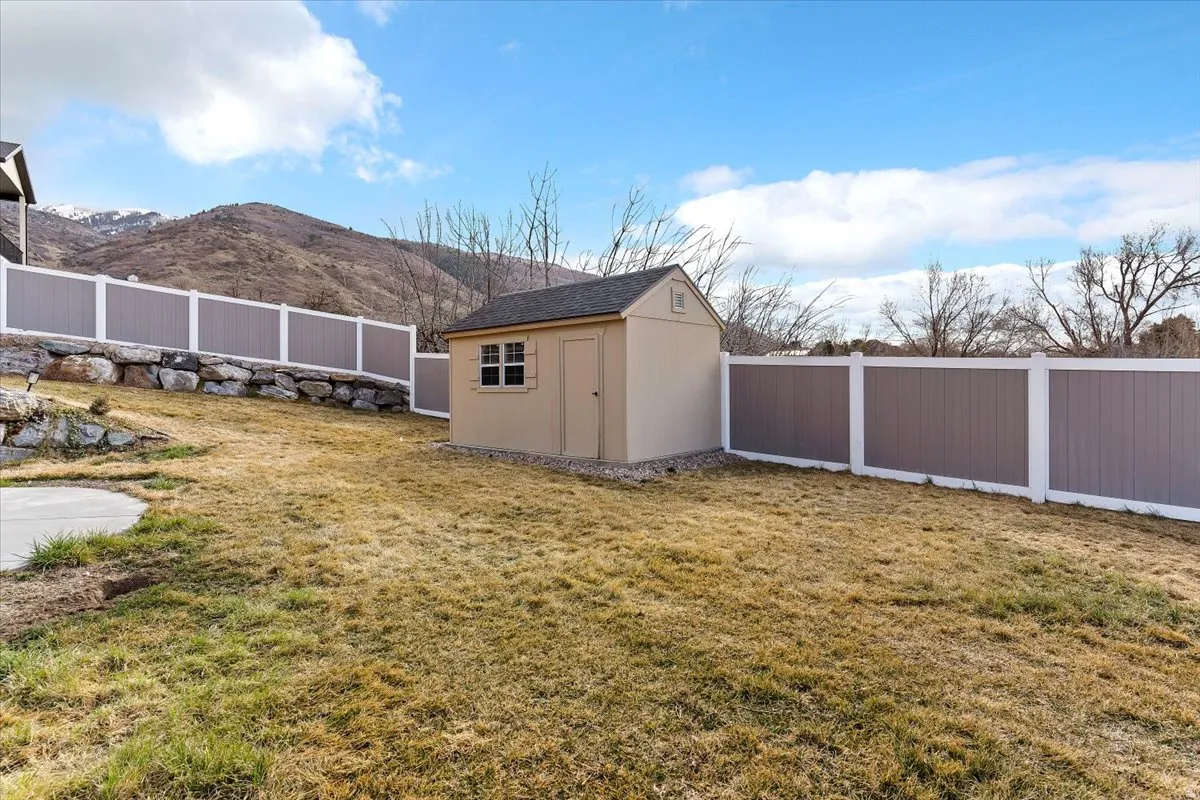 Fenced backyard with a mountain view and a storage shed