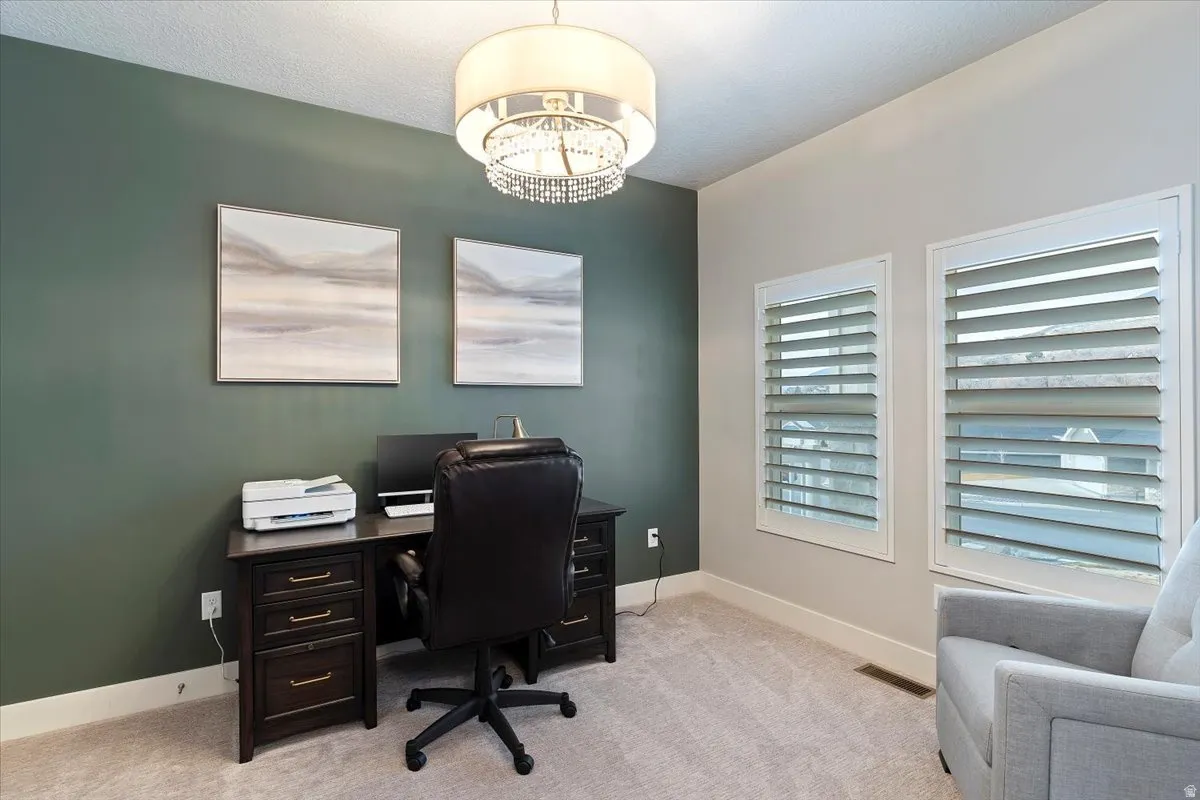 Office area featuring light carpet and suspended lighting