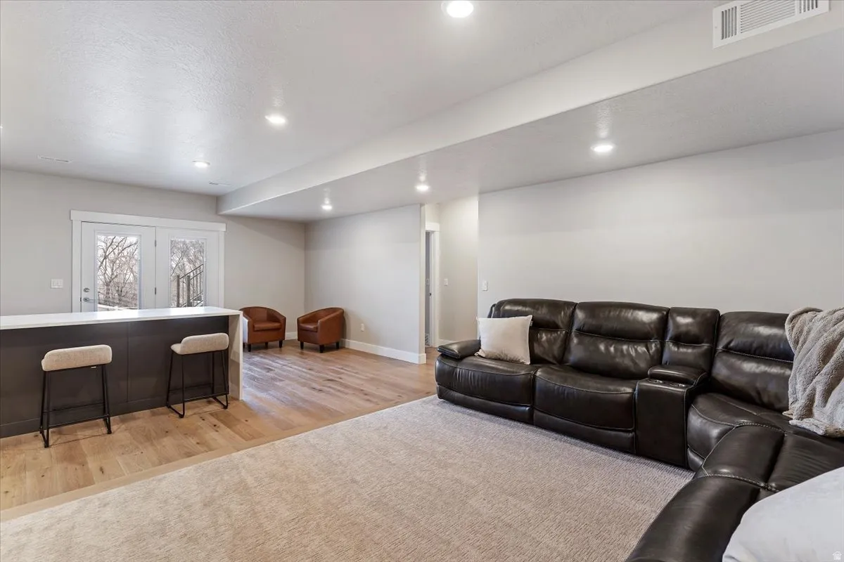 Living room with light wood finished floors and recessed lighting
