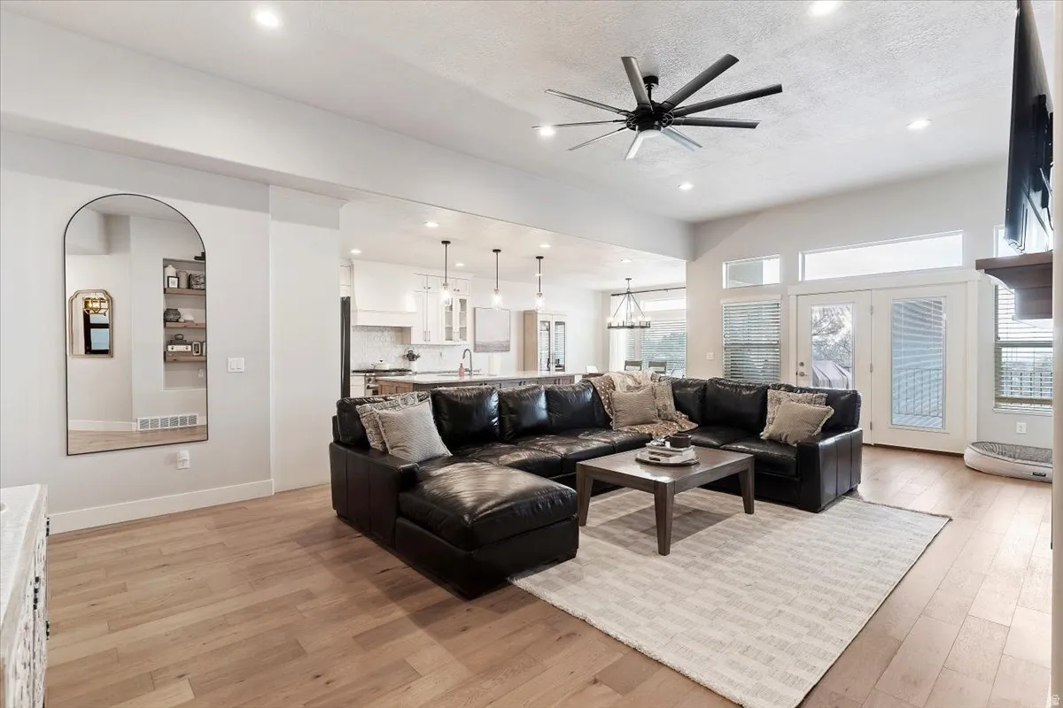 Living area featuring ceiling fan, light wood finished floors, and recessed lighting